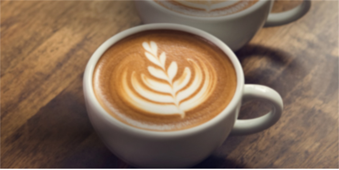 Latte in a cup with a beautiful design in the foam